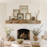 Cozy rustic vintage mantel with leaned art, brass candlesticks, and dried florals