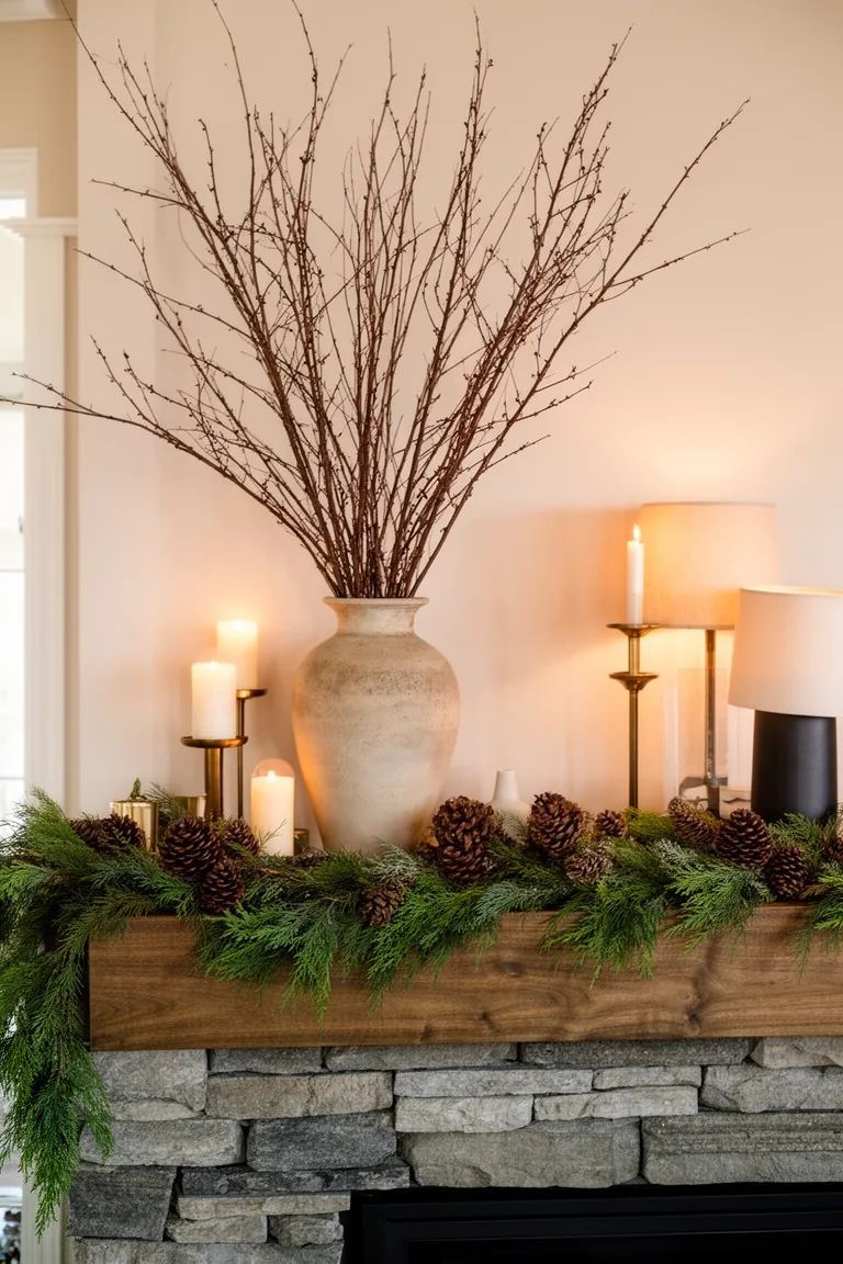 Tall bare dogwood and willow branches in a stoneware vase on a mantel