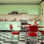 Retro 1950s diner kitchen with red vinyl chairs, a chrome dining table and a green checkerboard floor