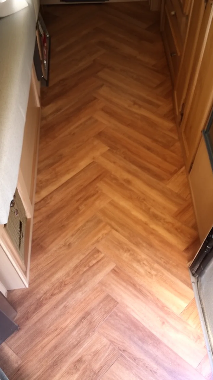 Warm oak herringbone vinyl flooring adding a designer touch to a camper floor