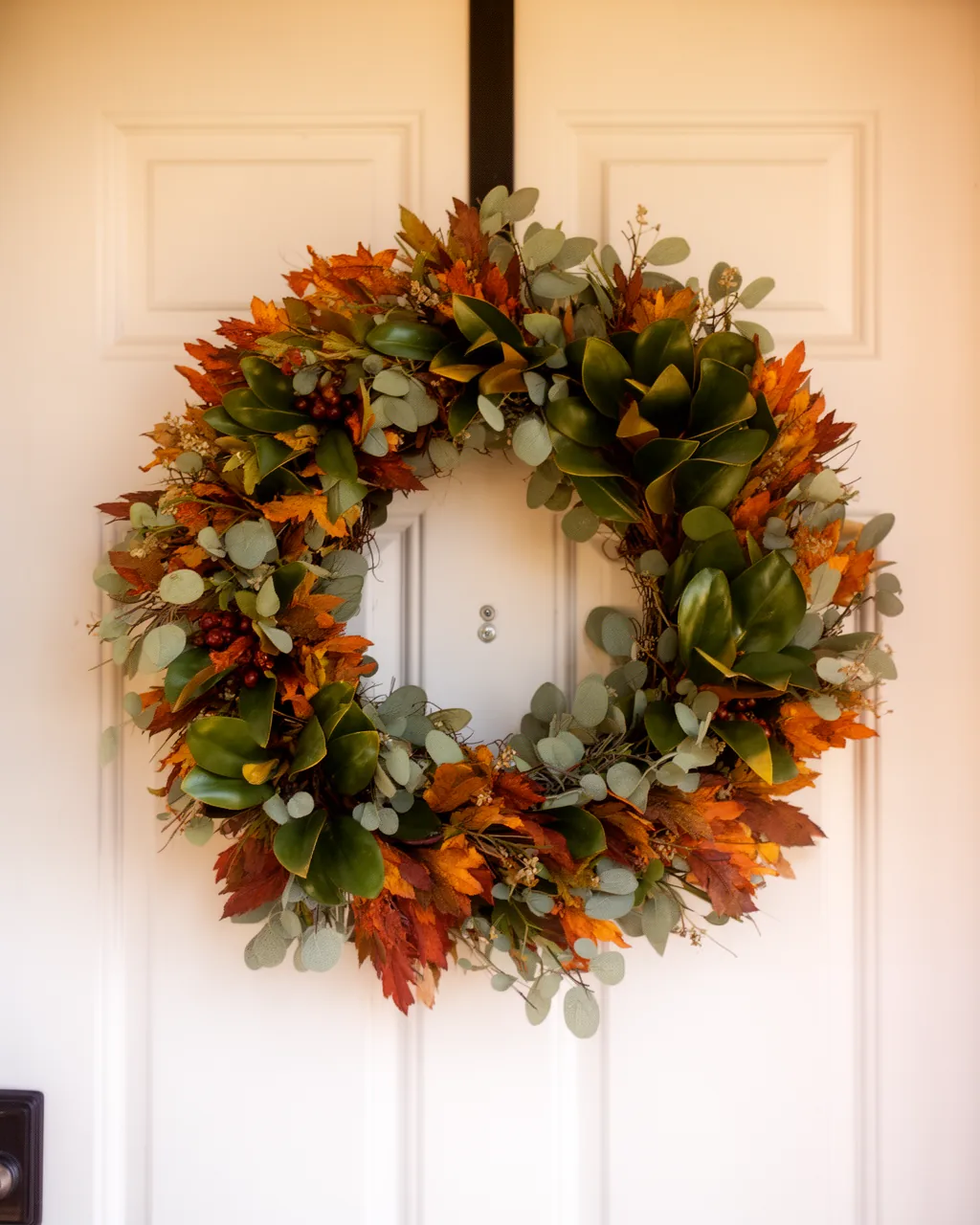 Magnolia and eucalyptus fall wreath on a white door