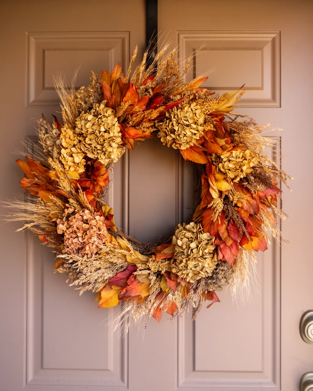 Dried hydrangea and grass wreath on a taupe door
