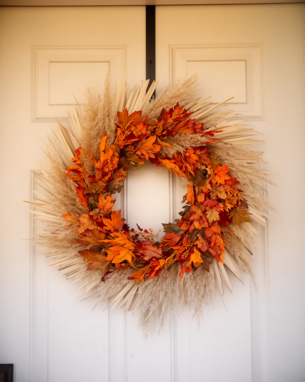 Neutral pampas fall wreath on a white door