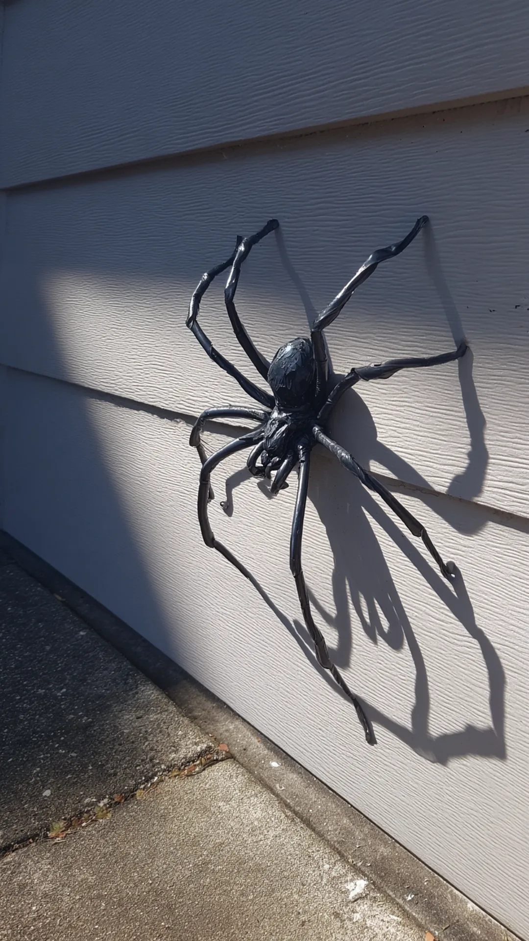 giant homemade spider mounted on a garage wall — photo 1 of 2