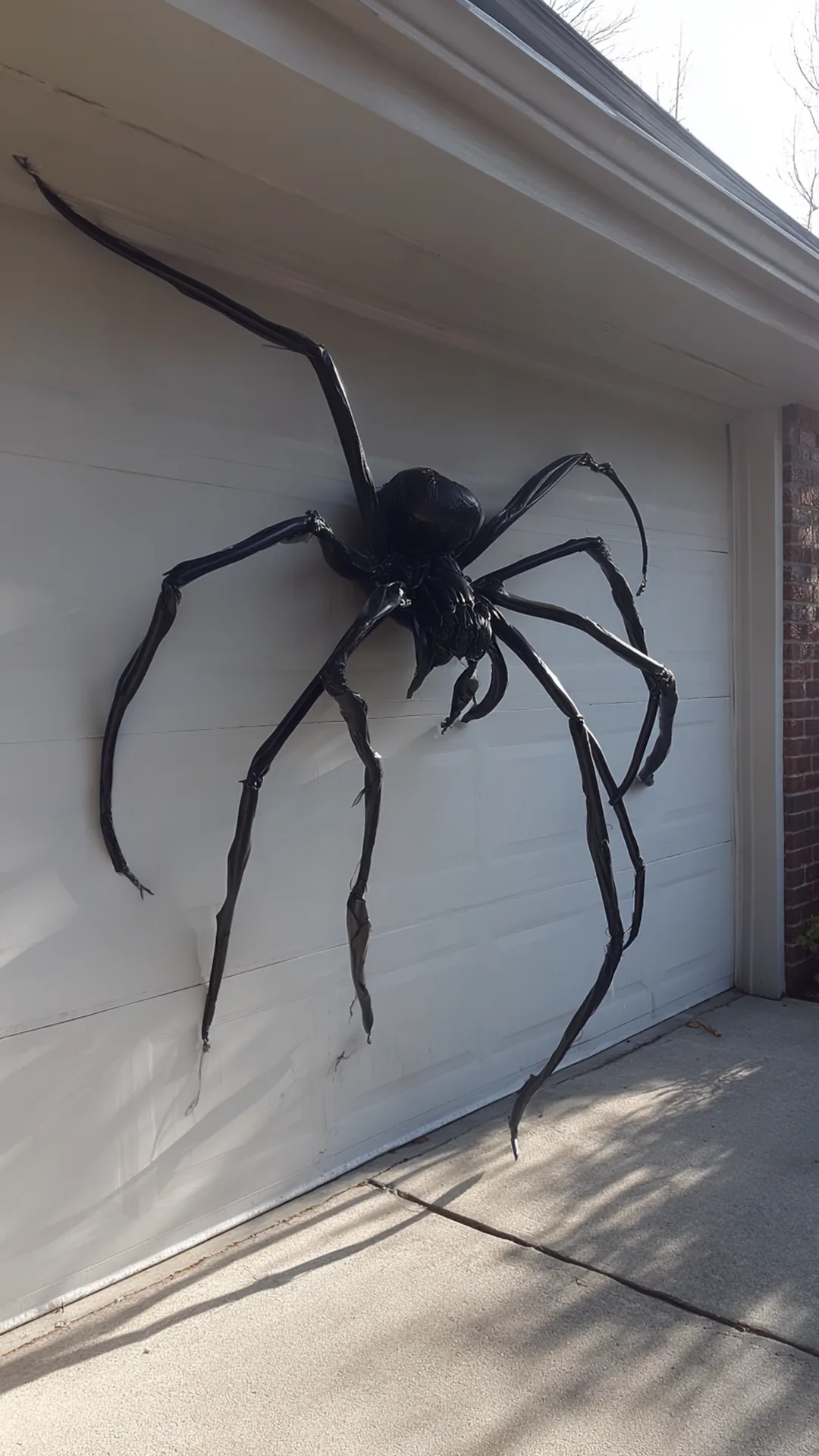 giant homemade spider mounted on a garage wall — photo 2 of 2