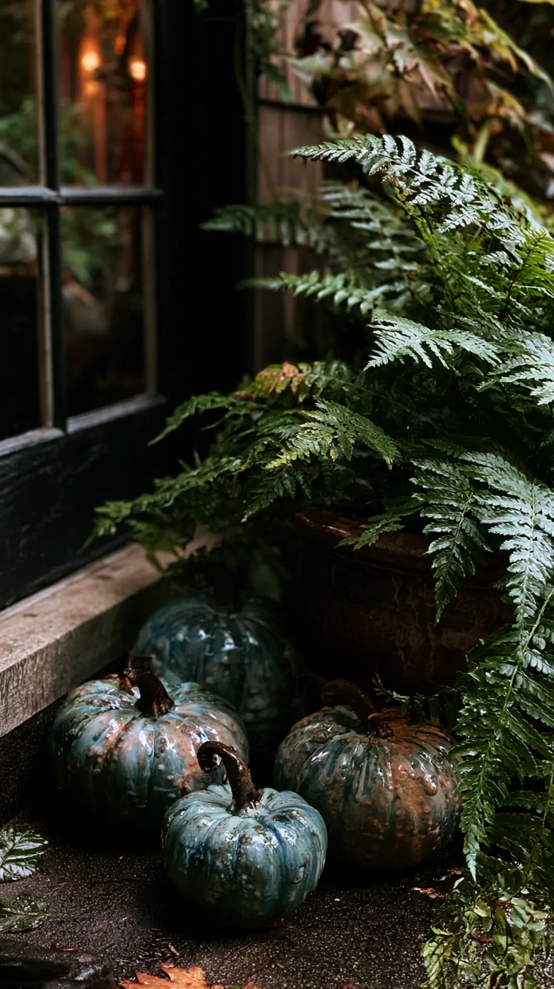 Glazed ceramic pumpkins arranged on a shaded, damp porch corner, photo 4 of 4