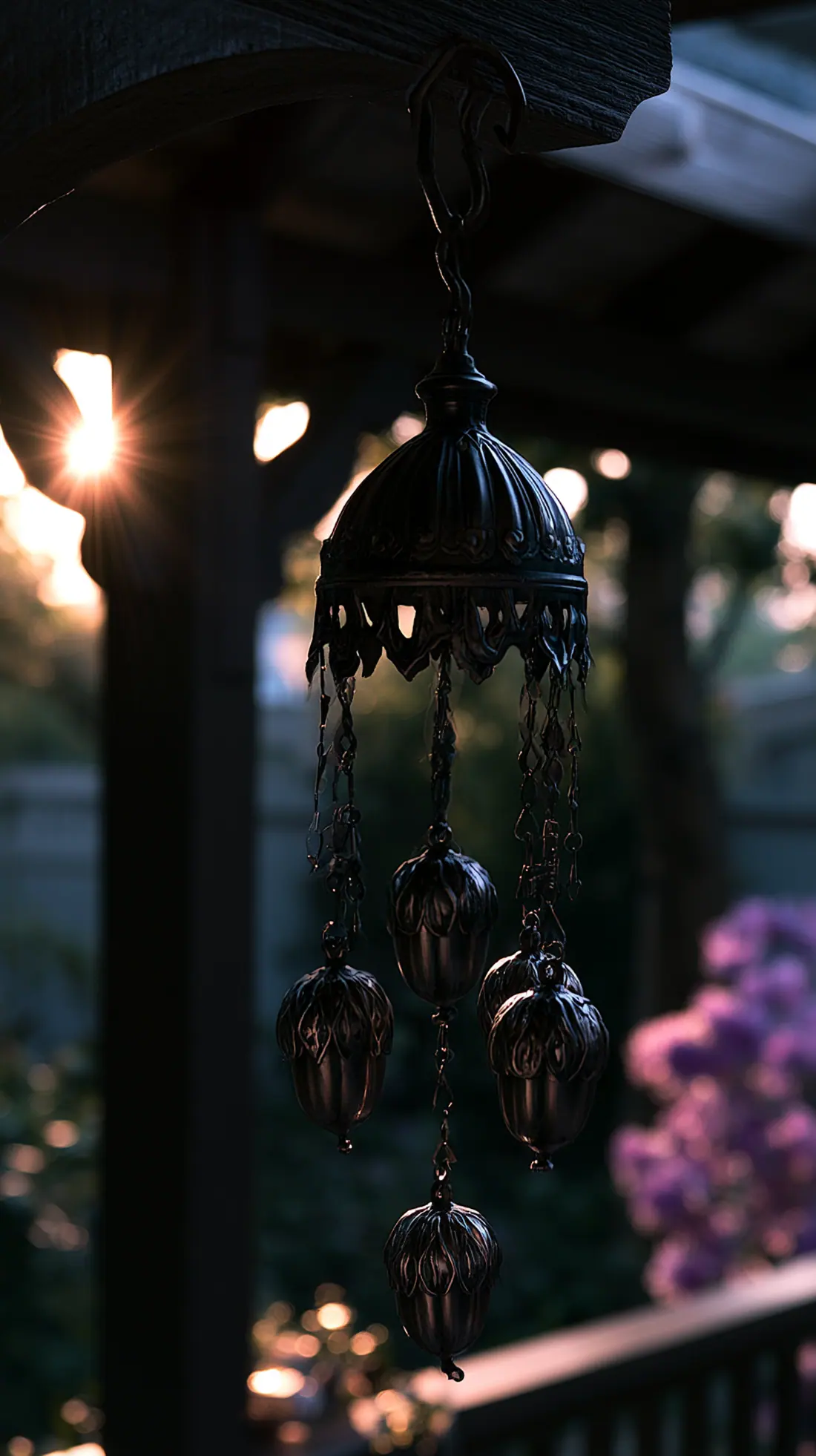 A metal wind chime with acorn details hung securely from a porch beam, photo 1 of 3