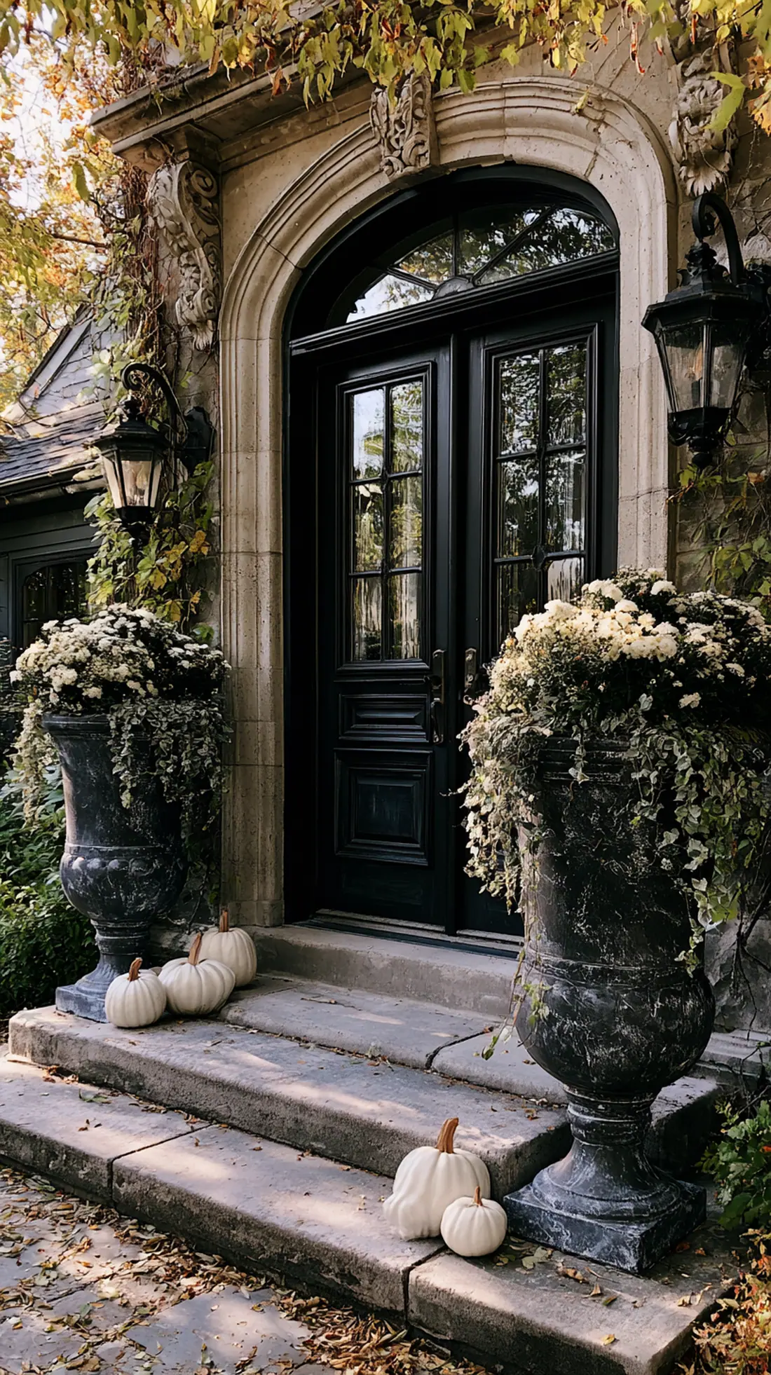 Matching weatherproof urns filled with pumpkins flanking the front door, photo 1 of 2