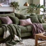 Olive green sofa living room with mauve pillows, brass lamp, and cozy textured throws
